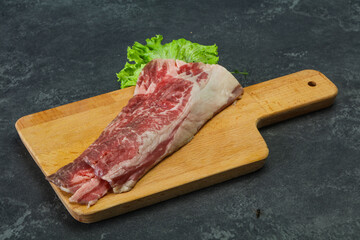 Fototapeta na wymiar Raw beef bacon over wooden board