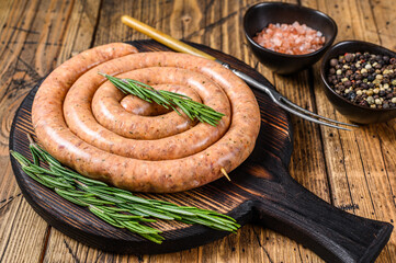 Raw spiral barbecue sausage from pork and beef ground meat. Wooden background. Top view