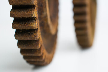 Rusty gears from an old mechanism on a white background, photographed up close.