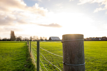 Shallow focus of a wooden fence post seen located within a public park. The fence is used to...