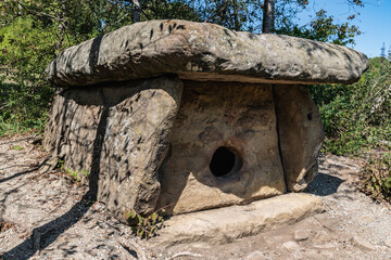 A large stone dolmen with a round entrance