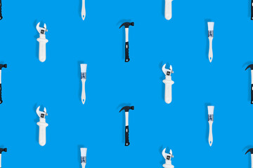 Tools seamless pattern. Tools: construction brushes, hammer, wrench on a blue background.