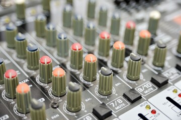 Multi-colored potentiometers on a mixing console, close-up.