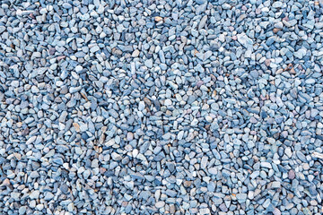 Gravel texture. Pebble stone background. Light grey closeup small rocks. Top view of ground gravel...