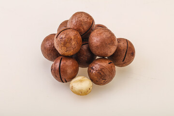 Brown macadamia nut heap over background