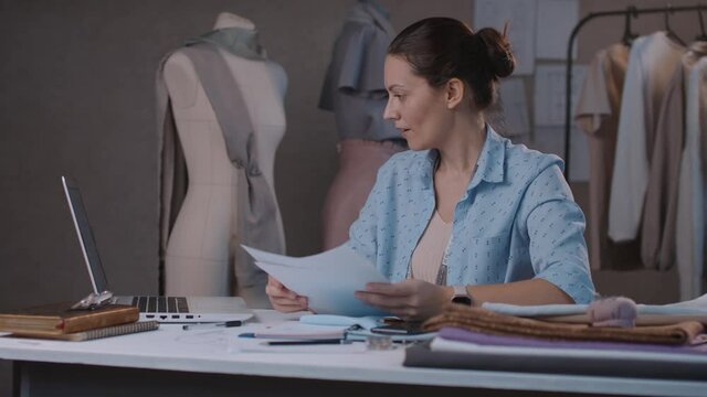 Fashion designer woman affably waves hand to online interlocutor in video conference on laptop. Smiling young woman video chat with online client