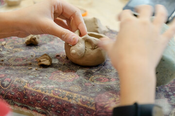 A child molds a product from clay in a modeling lesson.