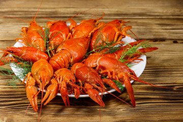 Boiled crayfish in plate on wooden table