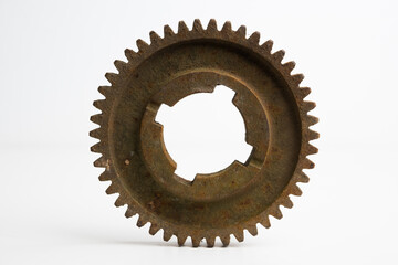 Rusty gear from an old mechanism on a white background, photographed up close.