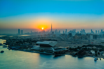 Sunset in Dubai view to downtown or Mohammed bin Rashid Library, panorama of Dubai. Sun sets over the skyscrapers or buildings in modern city