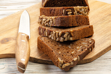 Loaf of rye bread and a pair of slices cut with a knife