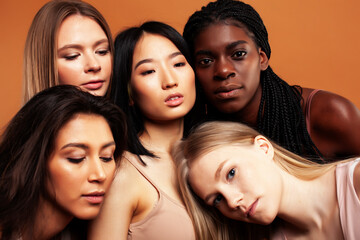 Obraz premium young pretty asian, caucasian, afro woman posing cheerful together on brown background, lifestyle diverse nationality people concept