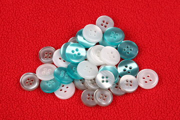 Plastic shiny buttons for clothes on a fabric background. Fashion and clothing. Factory industry