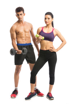 Athletic man and woman with dumbbells on the white background