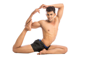 Obraz premium Young man is doing yoga isolated over white background