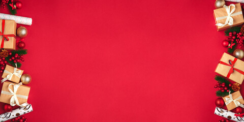 Festive New Year and Christmas picture for banners and greeting cards on a red background. Top view on christmas presents, christmas toys and balls. Image for holiday season and sales.