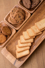Fototapeta premium wooden tray with many different types of cookies on wooden background.