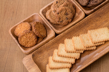 wooden tray with many different types of cookies on wooden background.