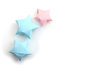 Blue and pink origami lucky stars on white