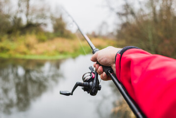 Man on the river bank throws a spinning rod. Fisherman throws spinning first person view
