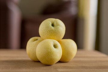 Fresh pears on wooden table in the room.