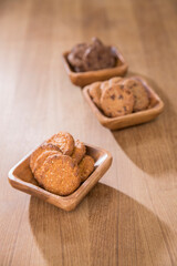 Fototapeta na wymiar wooden tray with many different types of cookies on wooden background.