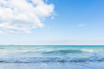 Naklejka na ściany i meble Sea waves and blue sky on sunny day background. copy space