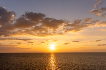 Sunset reflection ocean. beautiful sunset behind the clouds and blue sky above the over ocean landscape background