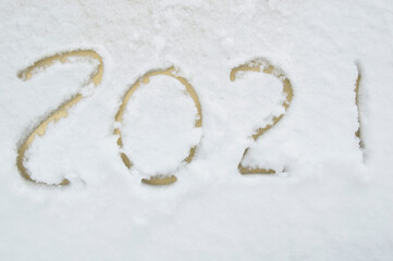 The numbers 2021 are written on snow. New Year's date concept. Inscription 2021.lettering on yellow car