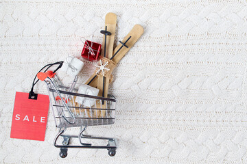 winter flat lay with sale tag, presents and shopping cart
