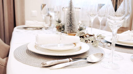 The girl with red nails removed the festive napkin from the plate. Christmas table setting