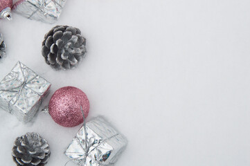 gift box, christmas balls and pine cones in the snow.flat lay.View from above.