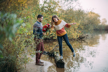 A romantic date, a walk in nature. Young couple of lovers together on the lake in early autumn