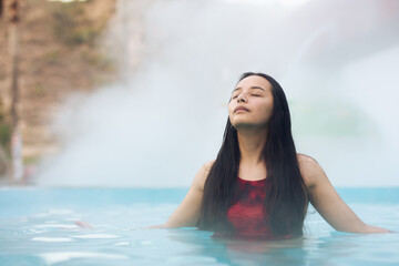 Young woman swimming in thermal waters pool