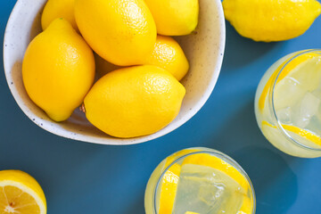 Lemons in bowl on blue background 