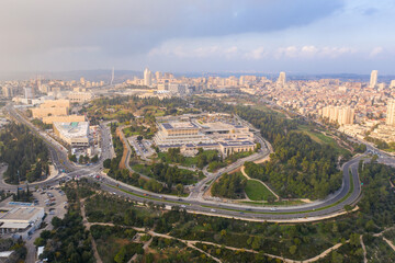 Fototapeta premium Aerial view of the Knesset, The Israeli house of Parliament, located in Jerusalem, with city rooftops in the horizon.