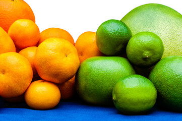 Isolated orange and green color groups citruses fruits on white background. Oranges, tangerines, limes, pummelo, grapefruits on blue tablecloth