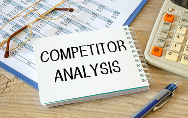 Notebook with text COMPETITOR ANALYSIS near office supplies.