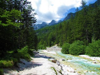 Fototapeta na wymiar Scenic Trglavska Bistrica aline river in Vrata valley in Slovenia and mountain peaks behind