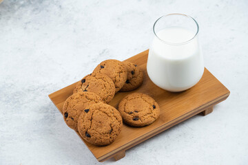 A glass cup with chocolate cookies on a wooden desk