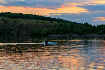 Man kayaking along the Dnieper river at sunset