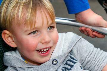 Primer plano de un niño rubio sonriendo con mirada indirecta.