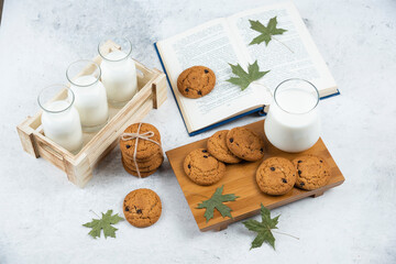 Fototapeta na wymiar Glasses of milk with chocolate cookies and book