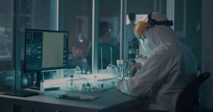 Doctor in protective suit researching vaccine in lab