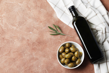 Composition of green olives and bottles of olive oil on the background. Space for text.