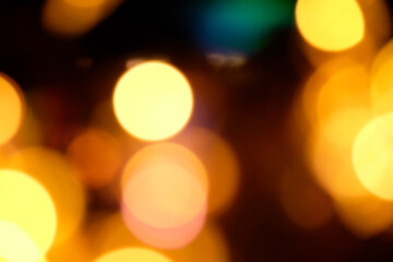 Fototapeta premium Blurred Christmas background, abstraction. orange and yellow glare garlands on a black background..