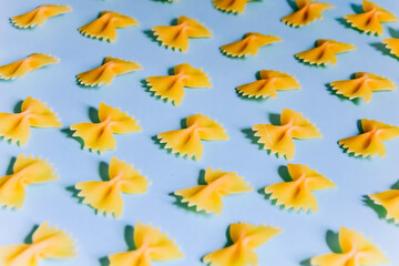 butterfly pasta on a blue background. whole grain pasta.