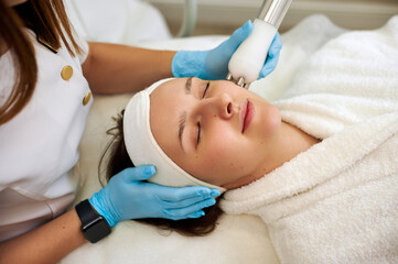 Beautiful woman receiving facial microcurrent procedure for lifting and rejuvenation skin.