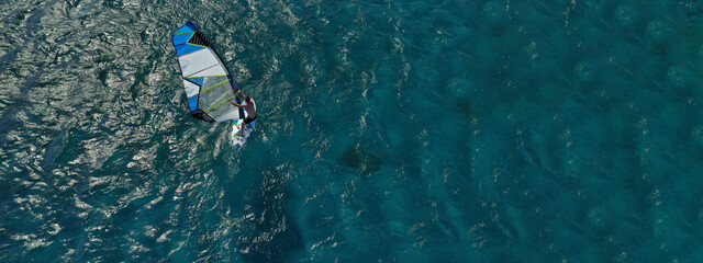 Aerial drone ultra wide photo of professional wind surfer practice in deep blue open ocean sea