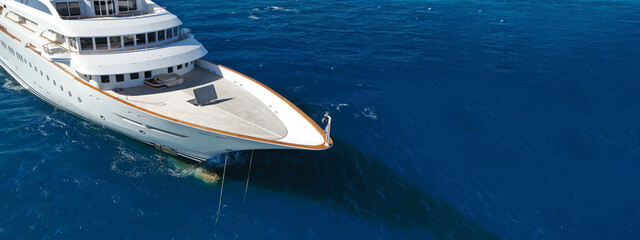 Aerial drone ultra wide photo of luxury yacht with wooden deck anchored in deep blue open ocean sea